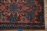 Fringe, meandering vine border, and floral motifs on a dusty raspberry vintage Mehriban rug.