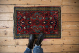 Vintage Borchalou rug corner, cherry red field with blue and saffron floral motifs.