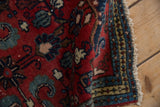 Vintage Borchalou rug's folded edge, showcasing cherry red field, navy floral motifs, and intact selvage.