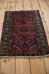 Angled view of a vintage Borchalou rug with dramatic, large-scale fuchsia arabesques.