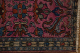 Corner of a vintage Borchalou rug showing the boteh border, rich fuchsia field, and short hand-knotted pile.