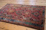 Vintage Mehriban rug showing intricate stylized serpent border and dusty raspberry palmettes.