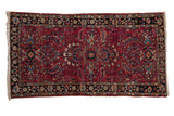 Vintage Persian Lilihan rug, raspberry red field with charcoal navy border and elaborate floral motifs.