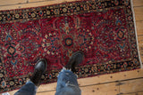 Vintage Lilihan rug with raspberry red field, scrolled leaves, and floral bouquets.