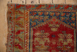 Worn cherry red field showing foundation and sapphire blue border on vintage Anatolian rug.