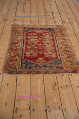 Vintage Anatolian rug corner: cherry red field with exposed knot heads, sapphire blue border, fringe.