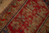 Worn cherry red field patterns on a vintage Anatolian rug with visible foundation.