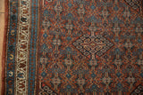 Vintage Hamadan rug's intricate brick red floral field and a dusty teal border.