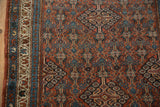 Hand-knotted vintage Hamadan rug corner detail: brick red field, dusty teal border, serrated spandrel.