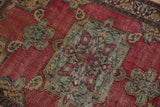 Antique Doroksh rug's worn cochineal red field with detailed teal and blush palmettes.