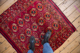 Overhead view of a vintage Turkmen rug's elephant footprint guls in fuchsia and navy.