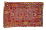 Vintage Anatolian rug with cherry red medallion, worn blush seeded field, floral arabesque border, 3'6