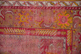 Close-up vintage Anatolian rug with floral arabesque border and visible wear.