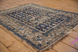 Antique Caucasian rug's sapphire blue field with geometric starbursts and serrated leaf border.