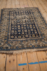 Antique Caucasian geometric rug's bottom edge, highlighting the beige and blue serrated border and aged fringe.