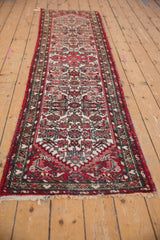 Vintage Borchalou runner's deep red side selvage with intricate vine and serpent borders.