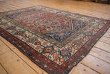 Ivory main border with finned floral and seed motifs beside brick red Herati field, vintage Malayer rug.