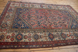 Close-up of vintage Malayer rug's ivory main border with finned floral cross-sections.
