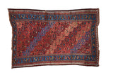 Vintage Kurd rug with diagonal shrubs and blossoms on an abrashed red field, framed by a bold sapphire blue border.