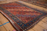 Low angle view of a vintage Kurd rug, highlighting the textured wool pile and geometric border.