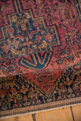 Vintage Senneh rug's thick pile, revealing raspberry red and navy blue geometric motifs.