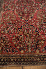 Detail of vintage Sarouk runner: dusty red floral field, geometric border, hand-knotted pile.