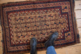 Antique Belouch rug's central field with tiered tree of life prayer motifs in camel, navy, apricot.