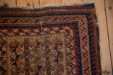 Antique Belouch rug corner, worn fringe and reciprocating wave border in navy, apricot.