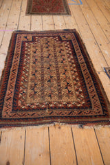 Worn fringe and geometric wave border of a camel and navy antique Persian Belouch rug.