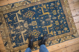 Corner of antique Caucasian rug, deep sky blue field, geometric animal motifs, ivory-gold border.