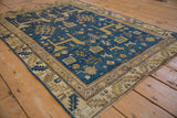 Geometric gold and ivory animal motifs on deep blue field of an early 20th century Caucasian rug.