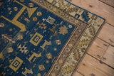 Antique Caucasian rug detail: deep blue geometric animals, dusty mauve, ivory borders.