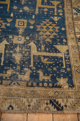 Geometric animals and birds on deep blue antique Caucasian rug, showing textured pile.