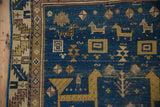 Geometric animal figures and tree-of-life motif on the deep sky blue antique Caucasian rug.