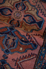 Hand-knotted Mehriban rug detail revealing raspberry, sapphire, copper tones, and visible knot heads.