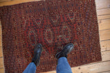 Deep red field with staggered navy gul medallions and hook-and-latch motifs.