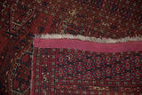 Vintage Turkmen rug foundation, with deep red and navy geometric weave, natural fringe.