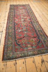 Vintage Heriz rug's red field, showing worn pile, exposed knot heads, and geometric floral motifs.