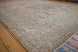 Worn pile texture and intricate pale mauve, ivory floral arabesques on a distressed Kerman carpet.