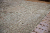 Distressed vintage Kerman carpet with low pile and subtle rococo floral patterns in neutral shades.