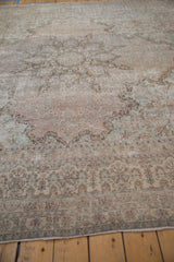 Distressed Kerman carpet's soft texture, faded floral motifs, and detailed border.