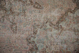 Worn Kerman carpet with Rococo stylized floral motifs in pale mauve, sea foam green, and brown.