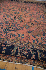 Dusty rose field of vintage Mahal carpet with sprawling navy, teal floral vines and scrolling border.