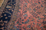 Sprawling blue vines on dusty rose field of vintage Persian Mahal carpet; ornate navy border.