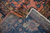 Corner of vintage Persian Mahal rug showing dusty rose pile and detailed hand-knotted navy blue foundation.