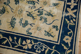 Corner detail of vintage Peking runner, cobalt blue vine-and-blossom border, scattered pale gold leaves on ivory field.