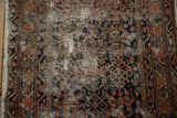 Vintage Hamadan rug showing extensive wear, exposed foundation, and faded Herati design.