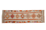 Vintage distressed Kurd rug runner, geometric serrated medallions on ivory with warm earthy tones.