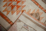 Vintage Distressed Kurd runner: ivory and orange pile texture, showing foundation and secured edge.