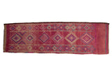 Vintage distressed Kurd runner with geometric diamond medallions in gem-like magenta, slate blue, and ivory tones.